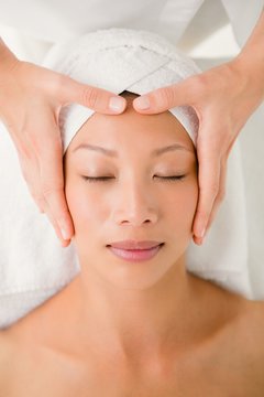 Attractive young woman receiving forehead massage 