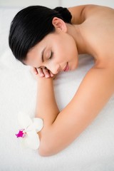 Obraz na płótnie Canvas Pretty brunette enjoying a massage with flower