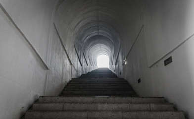 Light at the end of tunnel with ascending stairs