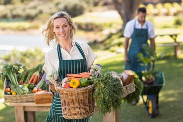 Fototapeta na wymiar Smiling farmer woman holding a vegetable basket