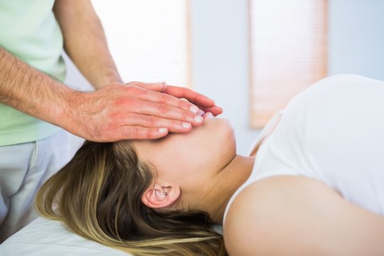 Close up view of relaxed pregnant woman getting reiki treatment