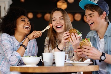 Cheerful multiracial friends eating in a cafe - 88917046