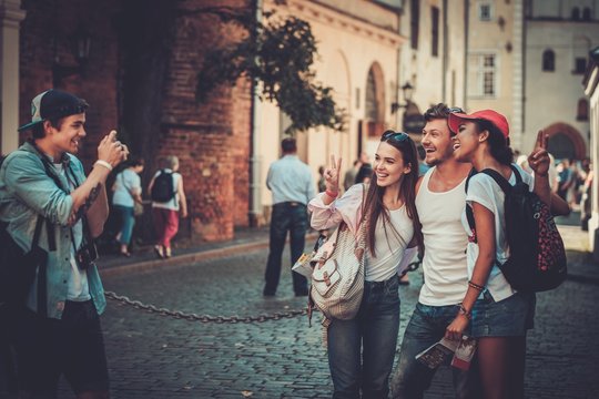 Multiracial friends tourists taking picture in an old city