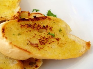 Close-up of a garlic bread on the white dish.