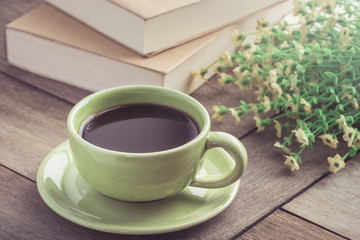 Coffee cup and book on wooden table, vintage style light