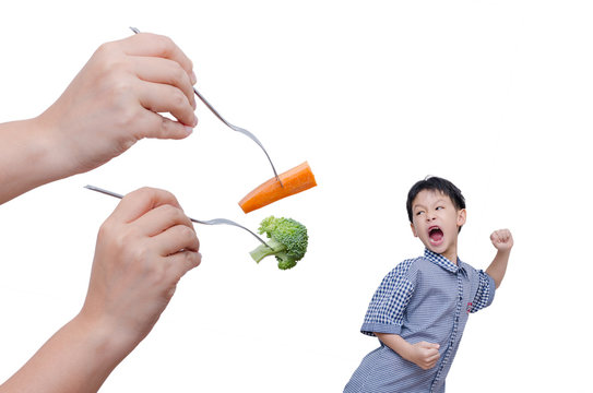Little Asian boy run away from eating vegetables over white