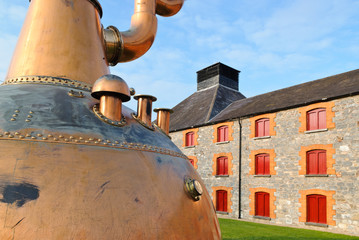 Whiskey distillery in Ireland with old copper kettle. - obrazy, fototapety, plakaty
