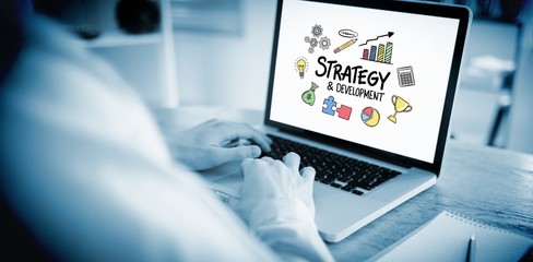 Composite image of businessman working on his laptop