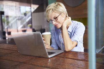 Businesswoman Working On Laptop In Coffee Shop