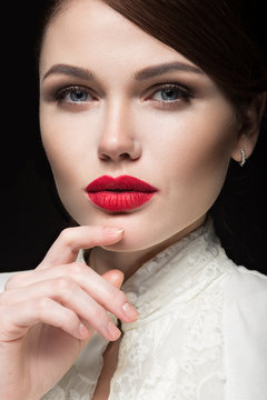 Beautiful girl with red lips in white clothes in the form of retro. Beauty face. Picture taken in the studio on a black background.