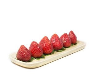 Strawberry in wooden dish on white background