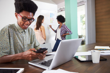 Three Businesspeople Having Creative Meeting In Office