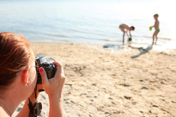 Mother making photo of children at the beach.