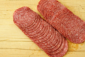Slices of salami on cutting board 
