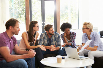 Businesspeople Having Informal Meeting In Modern Office