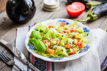 green vegetable salad with tomato, eggplant, sesame seeds and fl
