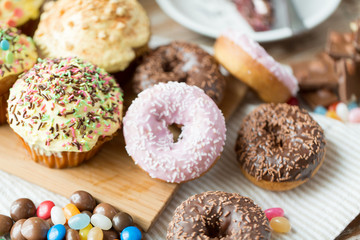 close up of glazed donuts and sweets on table