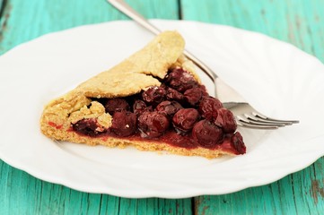 Piece of homemade vegan wholegrain galette with cherries with fo