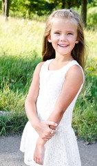 Fototapeta na wymiar Portrait of smiling cute little girl in summer day