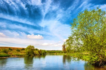 Foto op Canvas Uitzicht op rivieroevers met groene bomen © Pavlo Vakhrushev