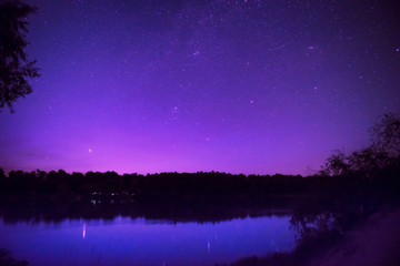 Beau ciel nocturne avec de nombreuses étoiles sur un lac