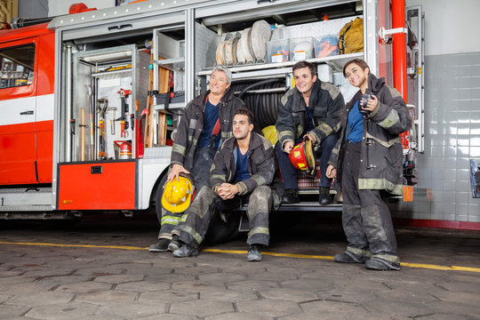 Team Of Thoughtful Firefighters By Firetruck
