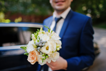 close up wedding bouquet at hand of groom