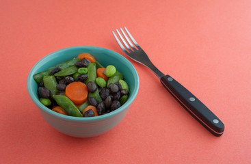 Buttered vegetables in a small bowl with fork