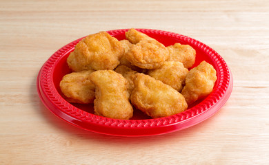 Chicken nuggets on a small red plate