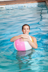 Man in the pool with inflatable ball