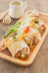 Spring rolls with vegetables and chicken on wooden plate