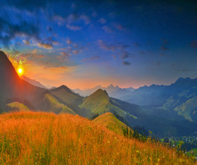 Sunset in summer mountains with early stars and lowly Sun 