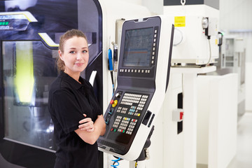 Portrait Of Female Engineer Operating CNC Machinery
