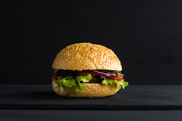 Burger on the black wooden background