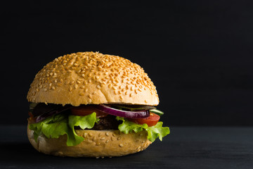 Burger on the black wooden background