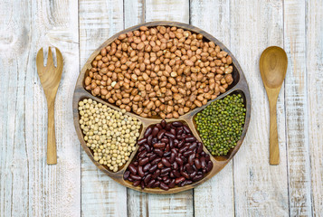 Collection of cereals, beans and grains on wood background