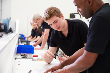 Obraz premium Engineer In Factory With Apprentice Checks Component Quality