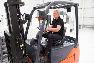 Male Fork Lift Truck Driver Working In Factory