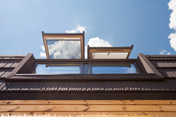 Open skylights (mansard windows) in wooden house with tile 