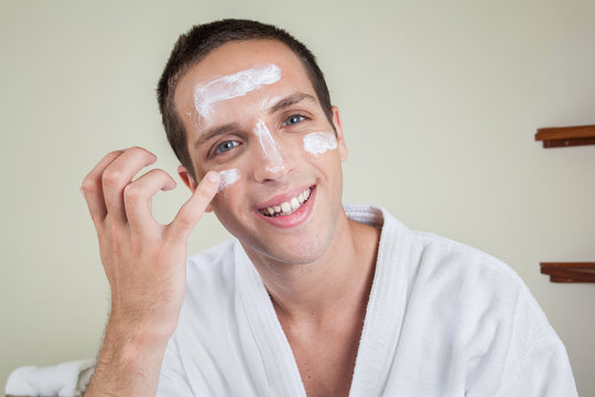 Happy Man Putting On Face Cream