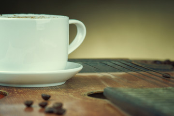Cappuccino coffee cup standing on the guitar