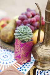 Wedding table arrangement in desert sand of Morocco stile. Fresh grapes near the salver with apples...