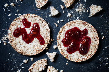 Round whole grain bread with jam without sugar on a dark backgro