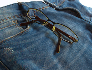 Modern glasses on jeans background