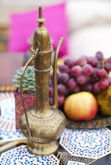 Obraz na płótnie Canvas Wedding table arrangement in desert sand of Morocco stile. Fresh grapes near the salver with apples and pears