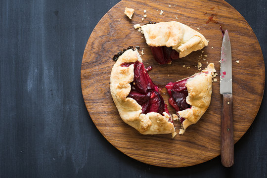 Homemade plum pie on the wooden cutting board