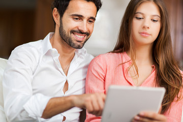 Obraz premium In love couple using a tablet computer in their living room