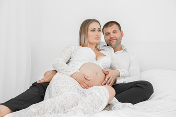 Pregnant lying on the bed with her husband