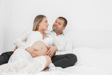 Fototapeta na wymiar Pregnant lying on the bed with her husband
