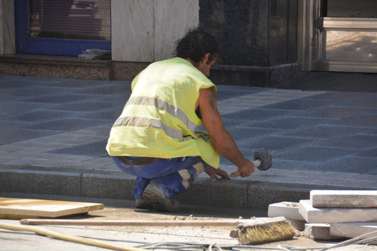 obrero martilleando el suelo
